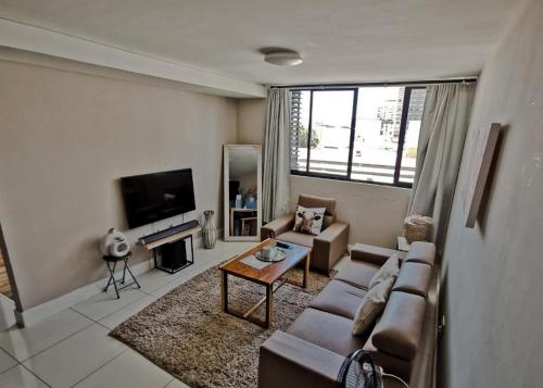 a living room with a couch and a table at The Safari Launchpad Windhoek in Windhoek