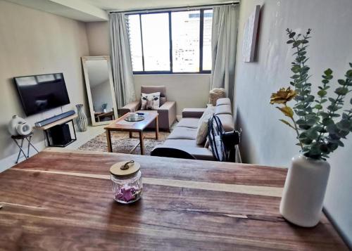 a living room with a wooden table and a living room at The Safari Launchpad Windhoek in Windhoek