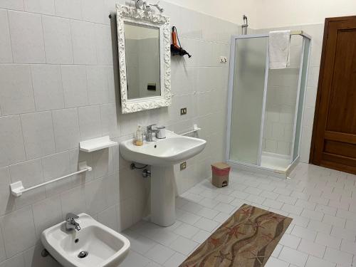 a white bathroom with a sink and a shower at Foresto Case Vacanza in Volta Mantovana