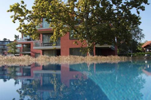 バラトンレッレにあるGemini Superior Apartman & Yachtの家が水のプールに映っている