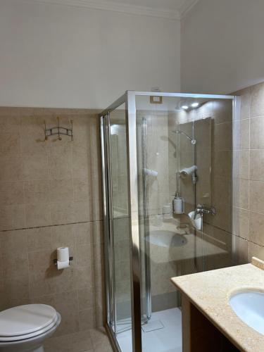 a bathroom with a shower and a toilet and a sink at Hotel Corallo in Torre Santa Sabina