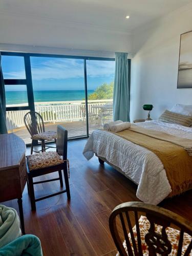 a bedroom with a bed and a view of the ocean at Skye Beach Villa in Tergniet