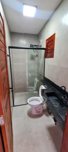 a bathroom with a pink toilet and a shower at Casapraiatracuá in Beberibe