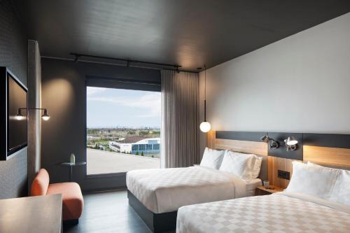 a hotel room with two beds and a window at Alt Hotel Ottawa Airport in Ottawa