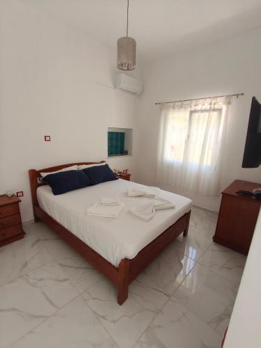 a bedroom with a large bed in a room at white and blue,finikas syros in Víssa