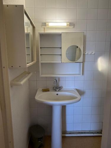 a white bathroom with a sink and a mirror at Appartement Port Leucate in Leucate
