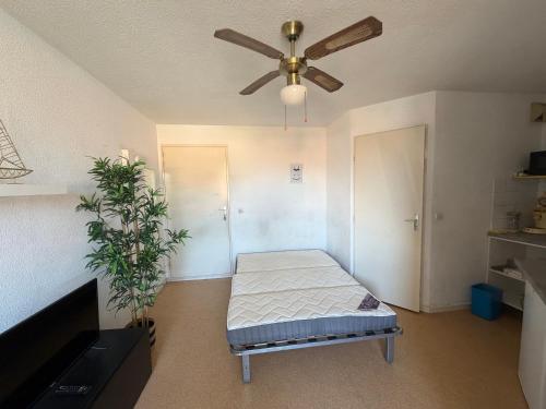 a room with a bed and a ceiling fan at Appartement Port Leucate in Leucate