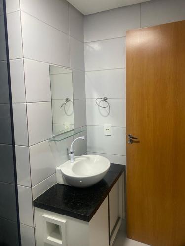 a bathroom with a sink and a mirror at Apto 2Q com Area de Lazer e Piscina in São Gonçalo do Amarante
