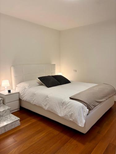 a white bedroom with a large white bed with two pillows at Villa Lena in Camaiore