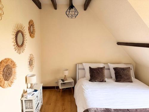 a bedroom with a bed with white sheets and pillows at Maison paisible Normandie in Saint-Aubin-de-Terregatte