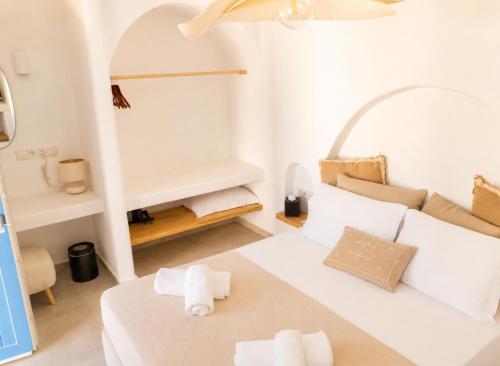 a small white room with a bed and a couch at Lodge Narlis in Platis Gialos
