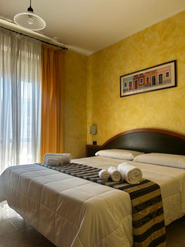 ein Schlafzimmer mit einem großen Bett, auf dem Handtücher liegen in der Unterkunft Hotel Blue Rose's in Mesagne
