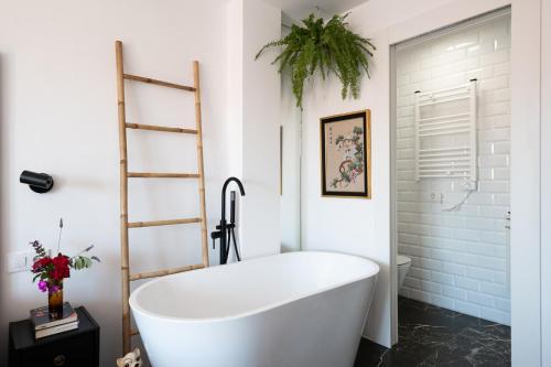 a white bath tub in a bathroom with a plant at Ático La Mallera in Luanco