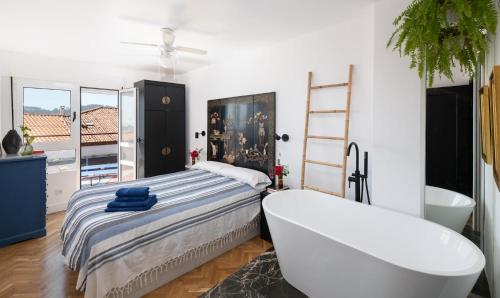 a bedroom with a tub and a bed and a bath tub at Ático La Mallera in Luanco