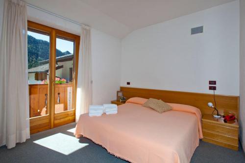 カスティオーネ・デッラ・プレゾラーナにあるHotel Cristallinoのベッドルーム(大型ベッド1台、大きな窓付)
