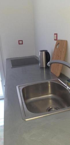 a kitchen counter with a stainless steel sink at white and blue,finikas syros in Víssa