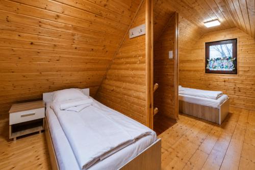 a room with two beds in a wooden cabin at Domki Nad Morzem Sobiescy in Stegna