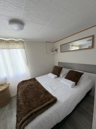 a bedroom with a bed with white sheets and a mirror at Maison 7 personnes avec piscine proche de Disneyland Paris in Villiers-sur-Morin