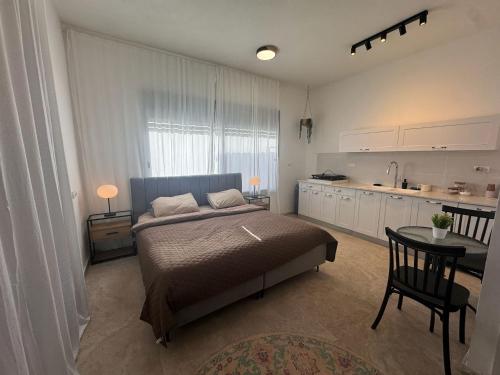 a bedroom with a bed and a table and a kitchen at קסם צפתי in Safed