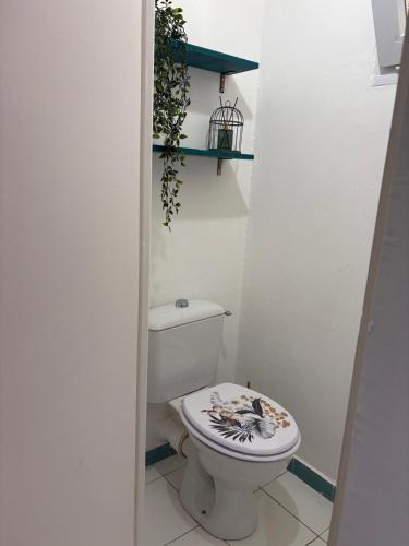 a bathroom with a toilet with a flower design on it at Appartement ALYA in Les Trois-Îlets