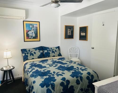 a bedroom with a blue and white bed and pictures on the wall at Nicole Guest House - Private Room & Bathroom - 6kms from City in Brisbane