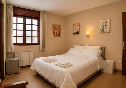a bedroom with a bed with two towels on it at Elara MSuites in Viveiro