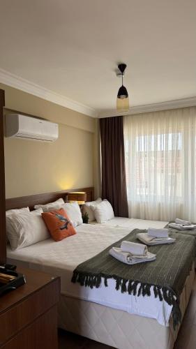 a hotel room with a large bed with towels on it at cunda panorama otel in Ayvalık