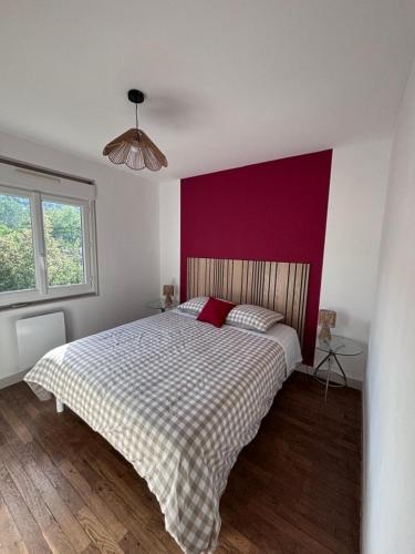 a bedroom with a large bed with a red wall at la maisonnette in Nogent-le-Rotrou