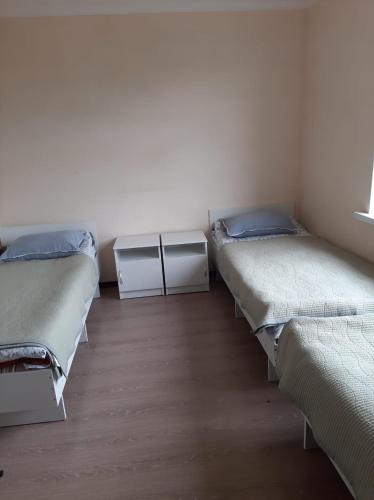 a room with three beds and a window at Guest House South Wind in Pokrovka