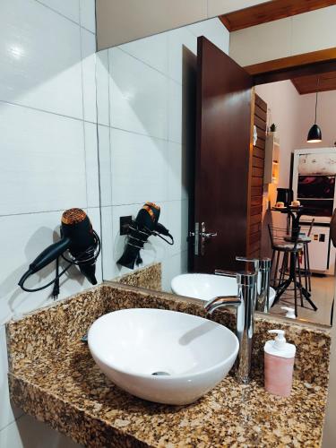a bathroom with a white sink and a mirror at Pousada Estrela Do Luar in Urubici