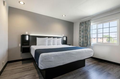 a bedroom with a large bed and a window at Studio 6 Rosemead, CA in Rosemead