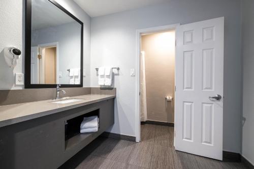 a bathroom with a sink and a mirror at Studio 6 Rosemead, CA in Rosemead