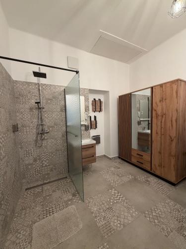 a bathroom with a glass shower and a sink at Zwinger Apartman in Sopron