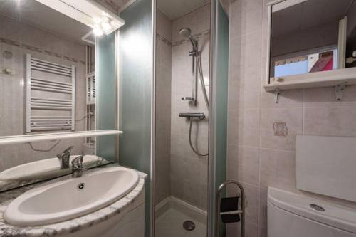 a bathroom with a sink and a shower with a mirror at Belledone in Les Menuires