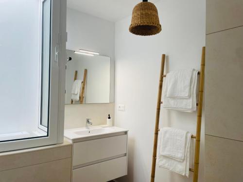a bathroom with a sink and a mirror and towels at Casa Señora Reyes in Famara