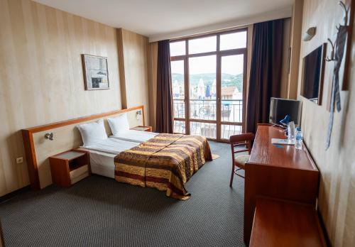 a hotel room with a bed and a window at Hotel Premier - Veliko Tarnovo City Center, Panorama View in Veliko Tŭrnovo