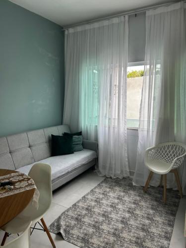 a living room with a couch and a window at Refúgios de Itaúna in Saquarema