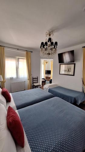 ein Schlafzimmer mit zwei Betten und einem Kronleuchter in der Unterkunft Hotel Los Caspios in Colunga