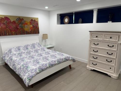 a bedroom with a white bed and a dresser at 2BDRM-Kitchenette-BBQ-Smart TV-4-5Guest in West Vancouver