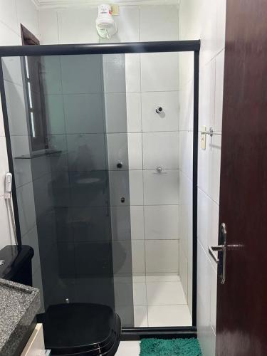 a bathroom with a glass shower with a toilet at Chalé Esmeralda in Gravatá