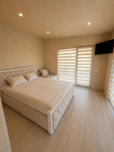 a bedroom with a large bed and a large window at Panorama Hrytsulivka in Vorokhta