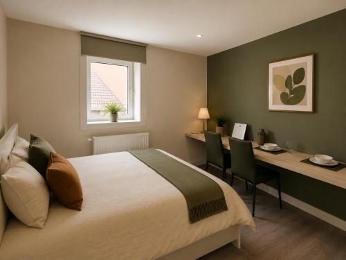 a bedroom with a bed and a desk with chairs at L' Gante in Ghent