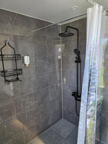 a bathroom with a shower with a shower curtain at APARTAMENTI BrivdienuKolka in Kolka