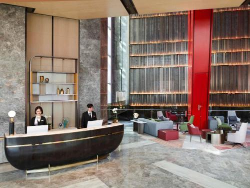 a lobby with two people sitting at a desk at Fairmont Ambassador Seoul in Seoul