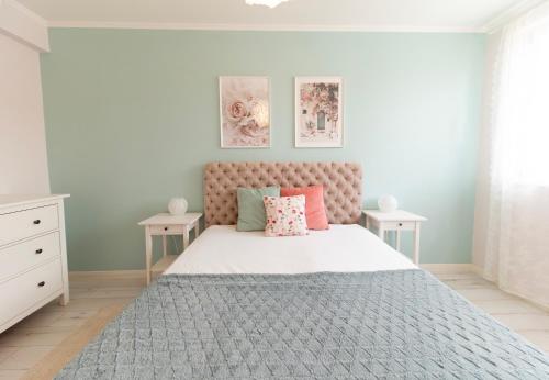a bedroom with a large bed with a pink headboard at Harmony Boutique Villa in Siófok