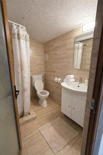 a bathroom with a white toilet and a sink at Vila Manila in Eforie Nord