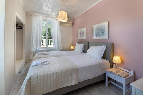 a bedroom with a large white bed with a window at Villa Maritsa, Magazia in Gaios