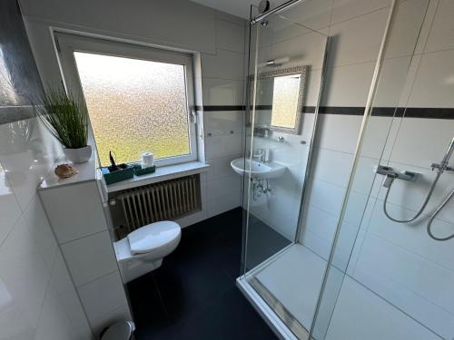 a bathroom with a shower and a toilet and a sink at Haus-36 in Neuss