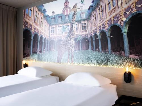 two beds in a room with a picture of a giraffe at ibis Styles Lille Neuville en Ferrain in Neuville-en-Ferrain