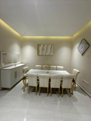 a dining room with a white table and white chairs at Luna Villa in Al Khobar